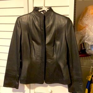 Black leather jacket with details in front cuffs and waist. By Ann Klein